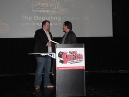 Chris Butcher manager of the Beguiling receiving the Harry Kremer Award for Outstanding Comic Book Retailer Award from Mark Askwith